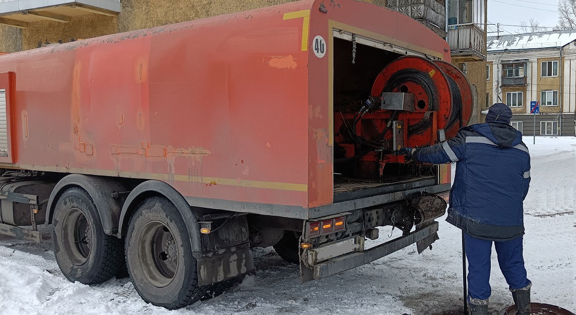 Каналопромывочная машина и работник прочищают засор в канализационной системе в Богучаре